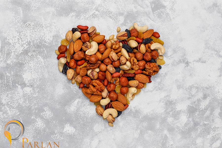assortment nuts shape heart cashew hazelnuts walnuts pistachio pecans pine nuts peanut raisins top view