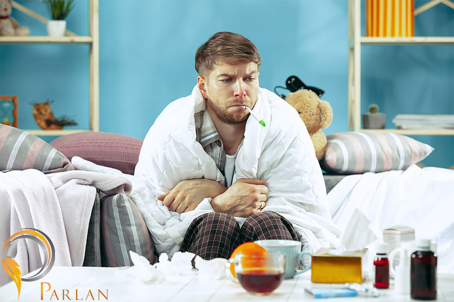 bearded sick man with flue sitting sofa home measuring body temperature winter illness influenza pain concept relaxation home healthcare concepts