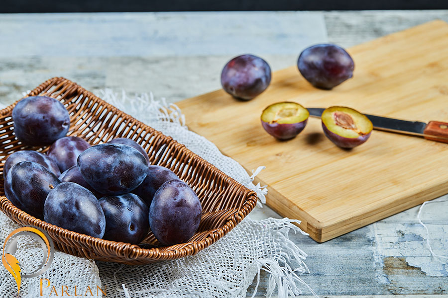 ripe-whole-half-cut-plums-wooden-board